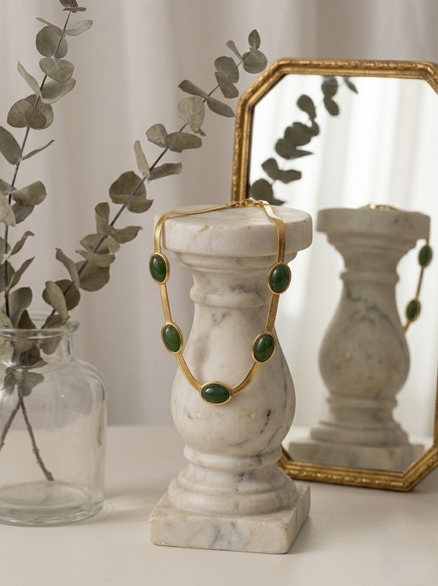 Elegant emerald green gold statement necklace with oval gemstone accents worn by a woman, chic minimalist choker jewelry for women with luxury-inspired design.